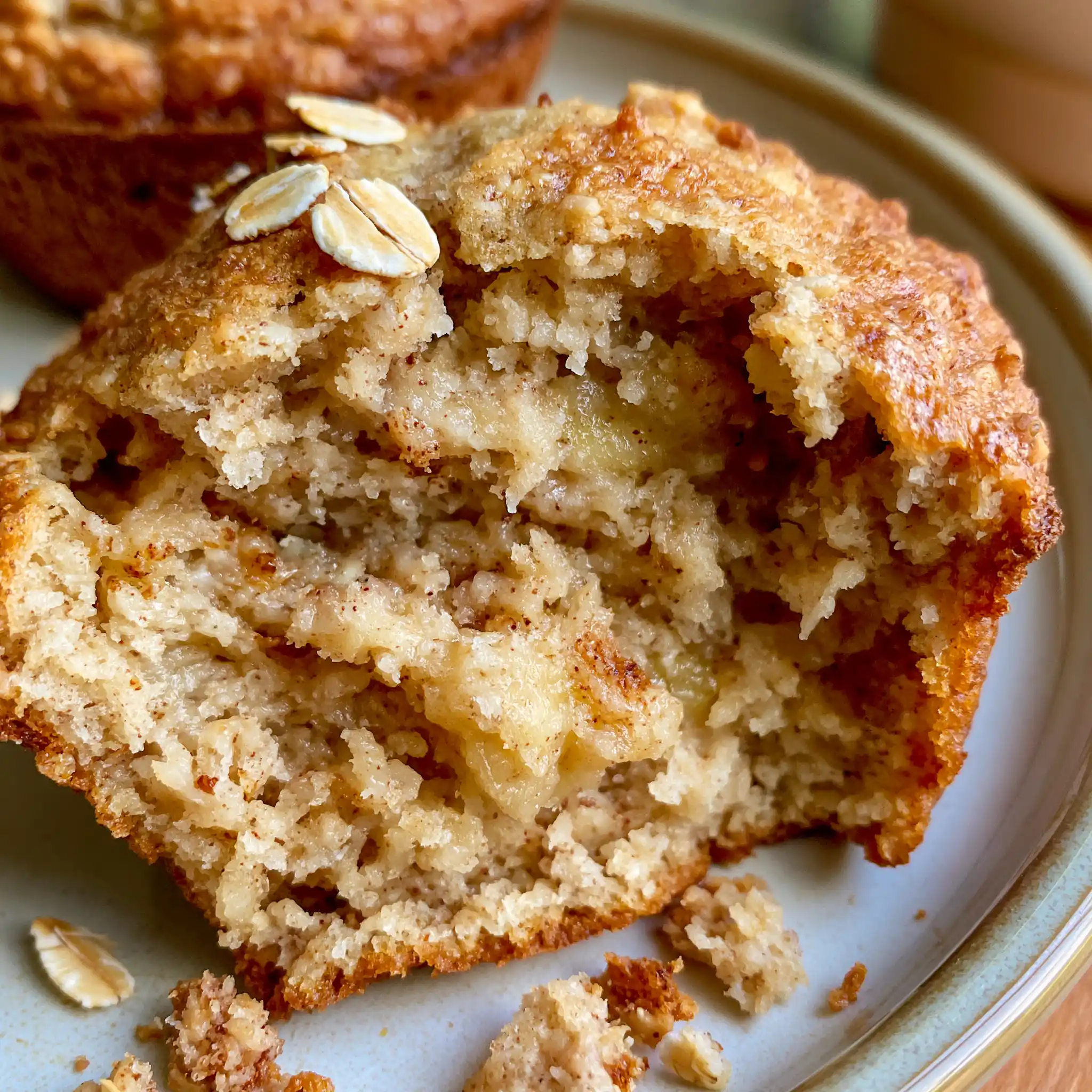 Close-up of a moist Banana Oatmeal Muffin showing banana crumb and rolled oat texture