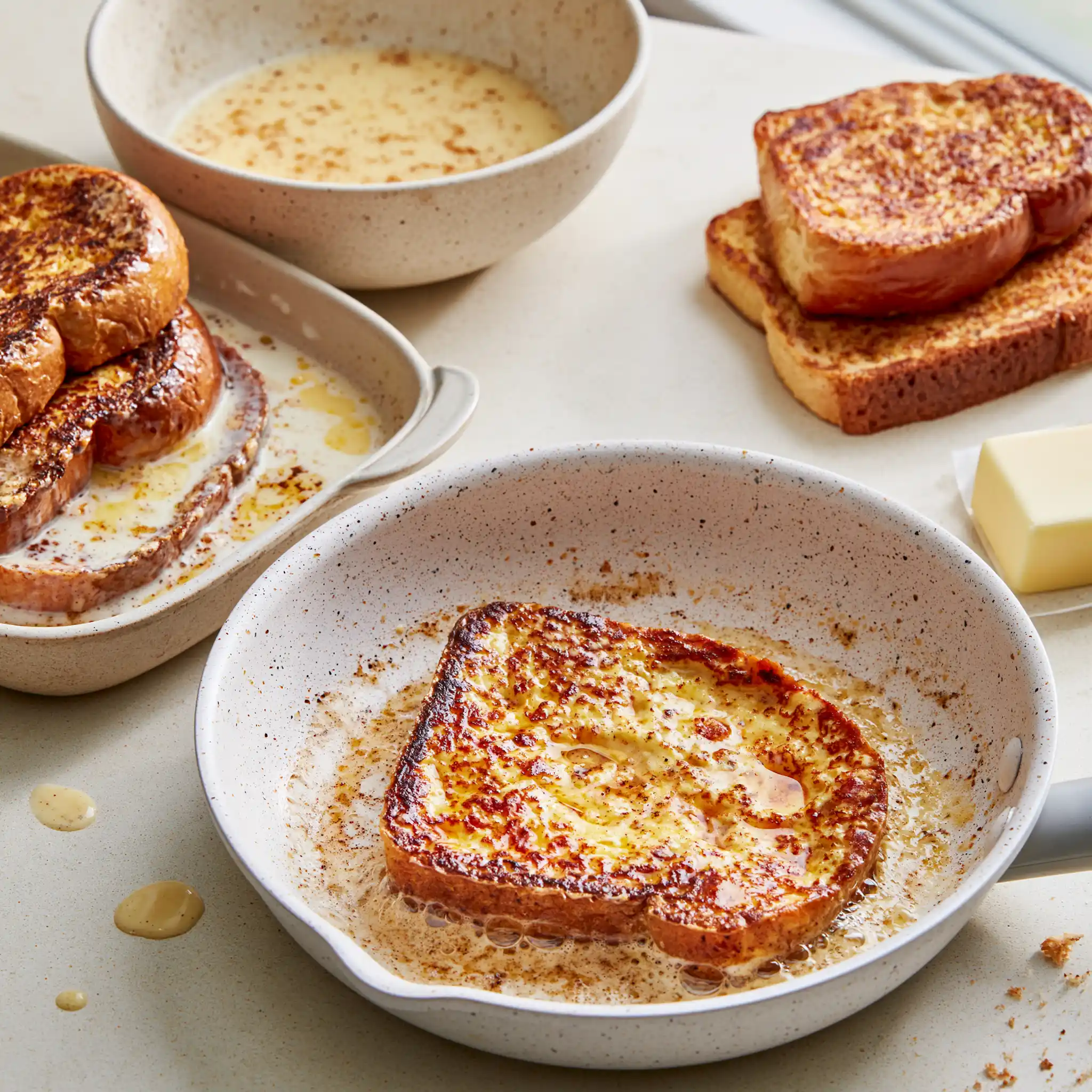Classic French Toast being prepared by dipping thick bread in vanilla cinnamon egg custard before cooking