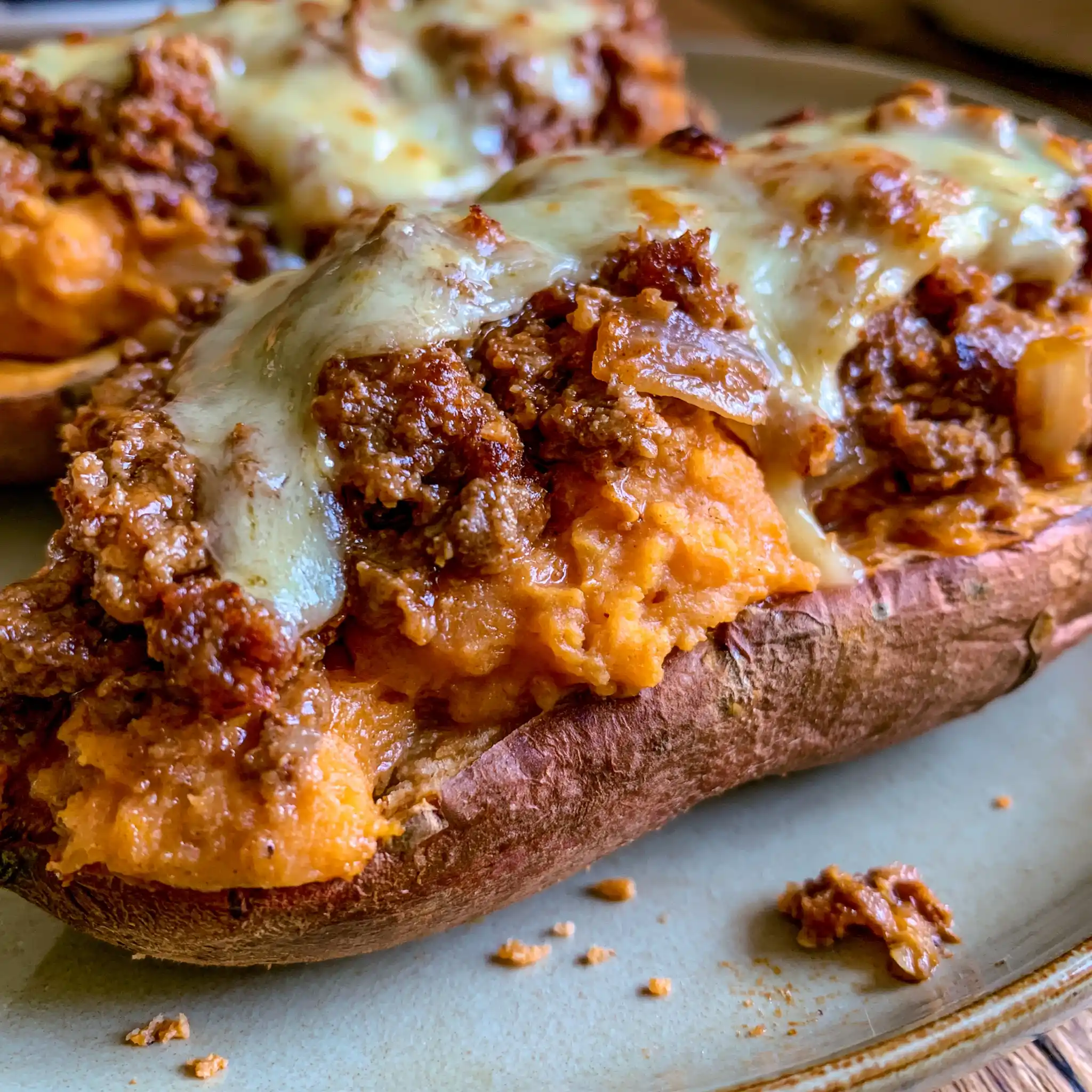 Close-up of a stuffed sweet potato with tender orange flesh, seasoned ground beef and melted cheese